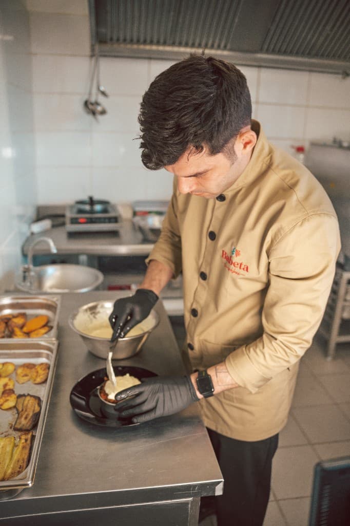 Savvas préparant un plat dans sa cuisine