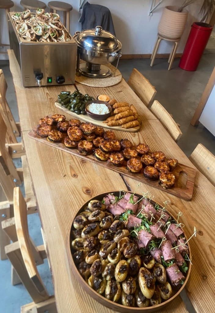 Buffet sur table en bois, feuilles de vigne, bouchées et viandes
